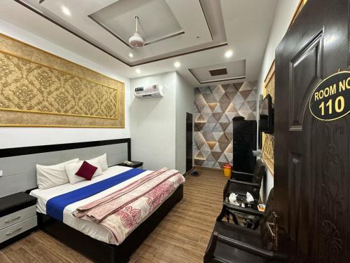 a bedroom with a bed with a blue comforter at Shelton Royal Hotel in Multan