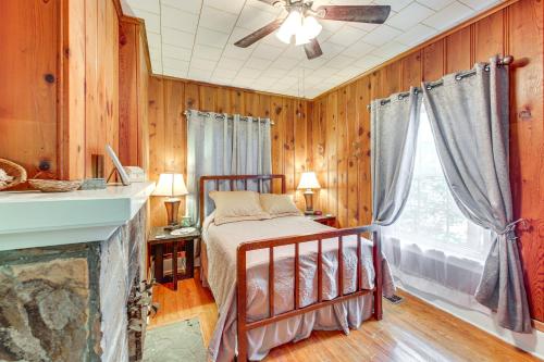 Un dormitorio con una cama en una habitación con paredes de madera. en Spacious Home Half-Mi to Oaklawn WFH Friendly!, en Hot Springs