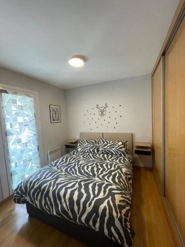 - un lit à motifs zébrés dans une chambre avec fenêtre dans l'établissement Appartement Aldapa, à Urrugne