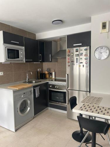 une cuisine avec un réfrigérateur en acier inoxydable et une table dans l'établissement Appartement Aldapa, à Urrugne