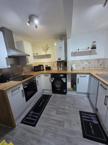 a kitchen with white cabinets and a dishwasher at Spacious - 8ight Havens Folkestone in Folkestone