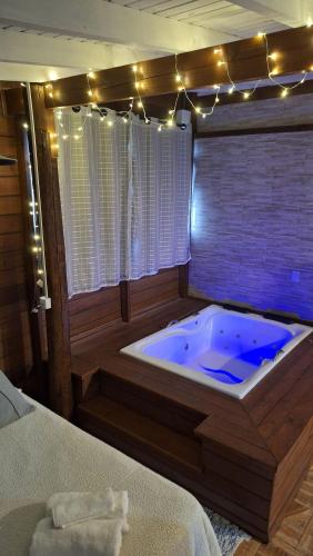a jacuzzi tub in a room with a bed at Pousada Pimenta Rosa - Praia do Rosa - SC in Praia do Rosa