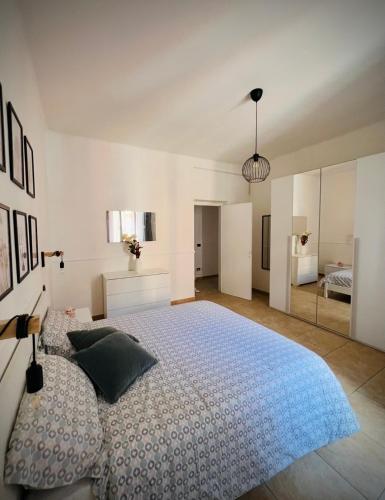 a white bedroom with a large bed and a mirror at La camera a due passi dal mare in San Terenzo
