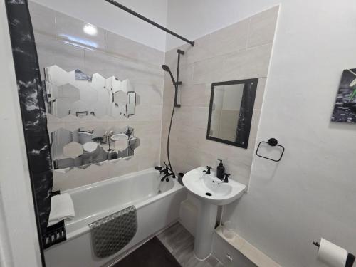 a white bathroom with a sink and a tub and a toilet at Spacious - 8ight Havens Folkestone in Folkestone