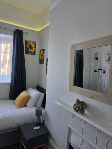 a bedroom with a bed with a mirror on the wall at Spacious - 8ight Havens Folkestone in Folkestone