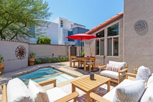 a patio with a table and chairs and an umbrella at Caballeros by ACME House Company in Palm Springs