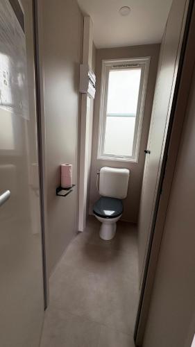 une salle de bain avec toilettes et fenêtre dans l'établissement Bungalow de charme près de Santa Giulia, à Porto-Vecchio