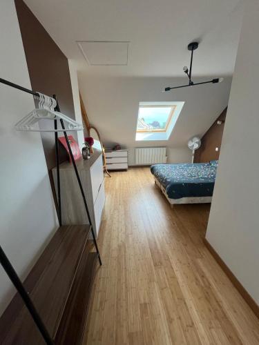 a attic room with a bed and a skylight at Maison proche Circuit des 24h du Mans in Saint-Gervais en-Belin