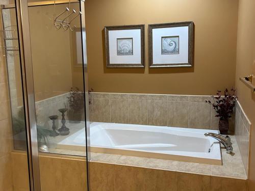 a bath tub in a bathroom with two pictures on the wall at Luxurious Bayville Shores Home Close to the Beach! in Selbyville