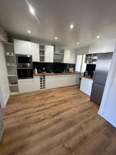 une cuisine avec des armoires blanches et un plancher en bois dans l'établissement Le Wilson Palace, à Antibes