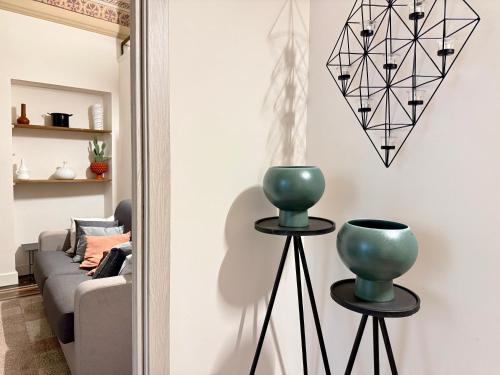 a living room with a couch and a vase on two stands at Casa San Pietro - Scicli in Scicli