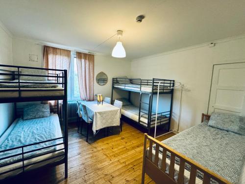 a room with three bunk beds and a table at Hässlebogården Turist & Konferens in Mariannelund