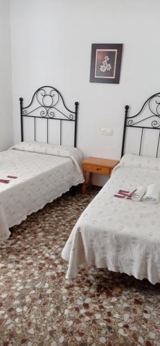 two beds sitting in a room with white walls at Apartamentos cañamares in Cañamares