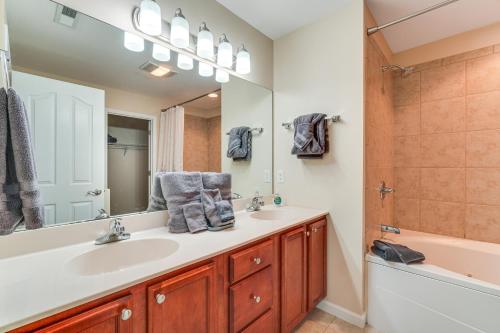 a bathroom with a sink and a tub and a mirror at Home 2 Mi to Island in Pigeon Forge! in Pigeon Forge