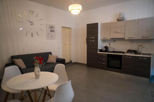 a living room with a couch and a table and a kitchen at Maison Alexeur in Crotone