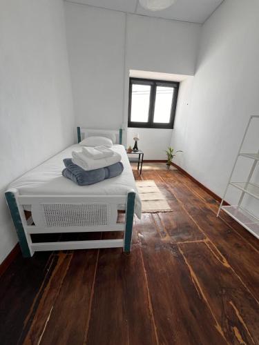 a white room with a bed and a wooden floor at Los Abuelos Vivienda Vacacional in Valverde