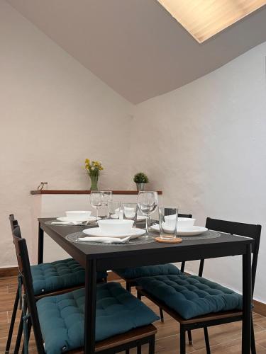 a dining room table with chairs and wine glasses at Los Abuelos Vivienda Vacacional in Valverde