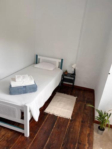 a bedroom with a white bed and a wooden floor at Los Abuelos Vivienda Vacacional in Valverde