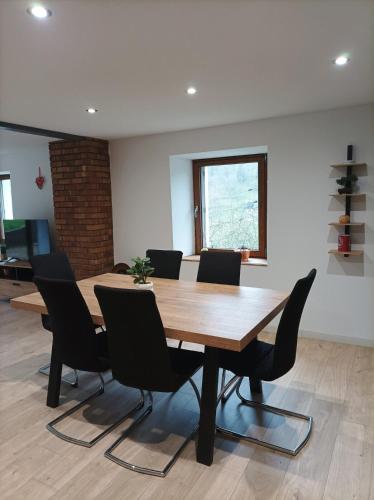 une salle de conférence avec une table et des chaises en bois dans l'établissement Le refuge de la source, à Bussang