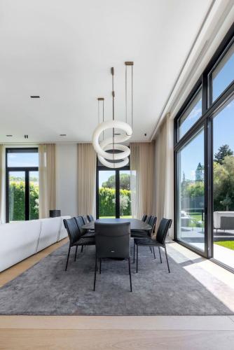 une salle à manger avec une table, des chaises et un lustre dans l'établissement Superbe villa d'architecte, à Mougins