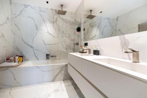 une salle de bain blanche avec un lavabo et un miroir dans l'établissement Superbe villa d'architecte, à Mougins