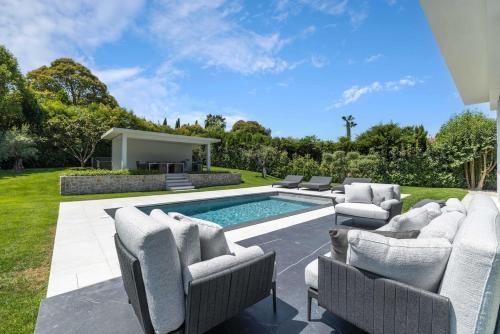 une arrière-cour avec une piscine, des chaises longues et une maison dans l'établissement Superbe villa d'architecte, à Mougins