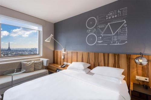 a bedroom with a large bed and a large window at Hyatt Regency Paris Etoile in Paris