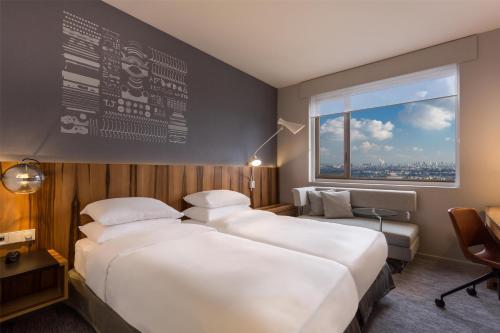 a hotel room with two beds and a window at Hyatt Regency Paris Etoile in Paris