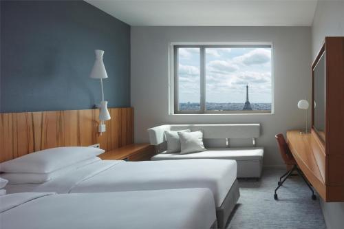 a hotel room with a bed and a window at Hyatt Regency Paris Etoile in Paris