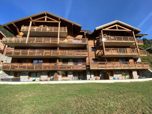 un grand bâtiment en bois avec balcon. dans l'établissement Champagny Les Alpages, à Champagny-en-Vanoise