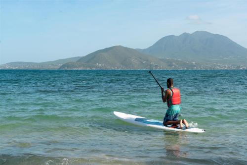 a man on a paddle board in the water at Park Hyatt St. Kitts in Christophe Harbour