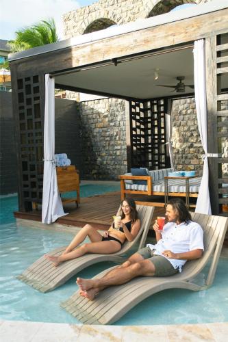 two people laying on chairs in the swimming pool at Park Hyatt St. Kitts in Christophe Harbour