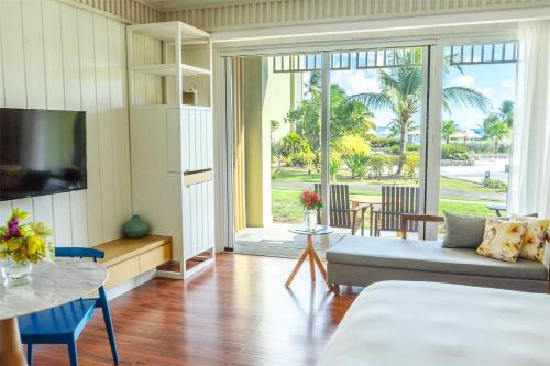 a living room with a couch and a tv at Park Hyatt St. Kitts in Christophe Harbour