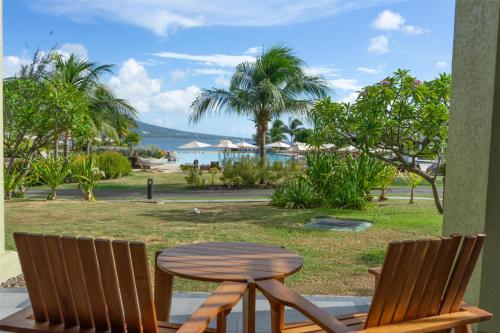 a wooden table and two chairs sitting next to a table at Park Hyatt St. Kitts in Christophe Harbour