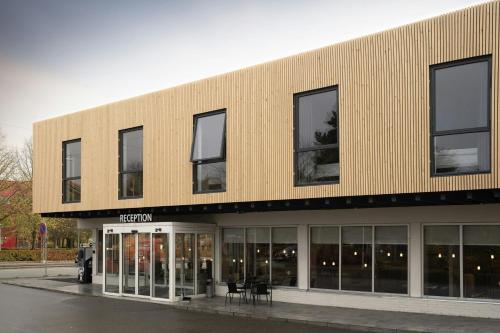 a large building with windows and tables in front of it at Four Points Flex by Sheraton Copenhagen Airport in Copenhagen