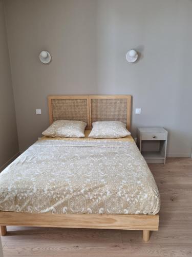 une chambre avec un grand lit avec une tête de lit en bois dans l'établissement Le Terrazzo - Jardin & confort, à Meximieux