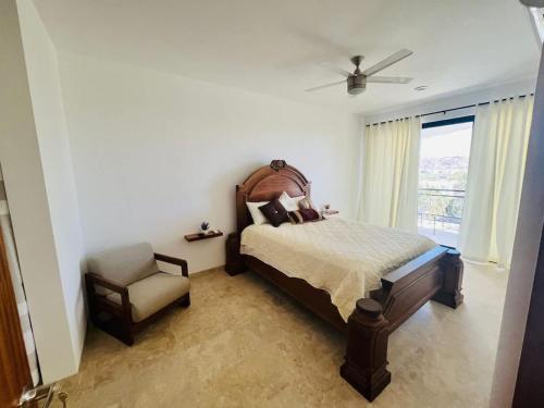 a bedroom with a bed and a chair and a window at Spacious and luxurious Yumil Condominium 137m2 in Los Barriles