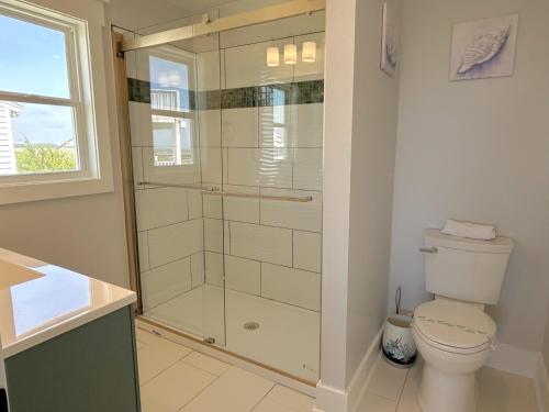 a bathroom with a toilet and a glass shower at Fishin' Shack in Oak Island