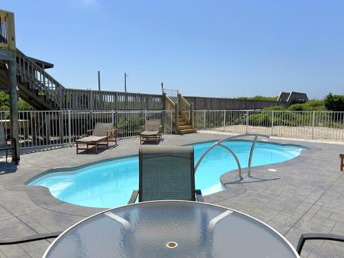 a swimming pool with a table and chairs next to it at Fishin' Shack in Oak Island
