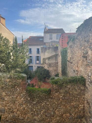 a stone wall with a building in the background at Studio des fleurs in Céret