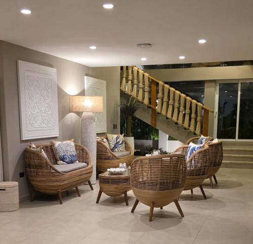 a lobby with wicker chairs and a staircase and a room at The Providence Hotel Boutique in San Andrés