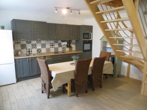 une cuisine avec une table et des chaises ainsi qu'un escalier dans l'établissement Ti gwenn 6p-Maison 3ch-Terrasse Port Maria Wifi, à Quiberon