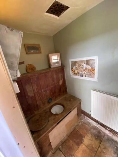 a bathroom with a toilet in the corner of a room at The Shepherds Hut in Hindringham