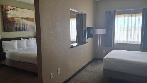 a hotel room with two beds and a mirror at Island Suites in Lake Havasu City