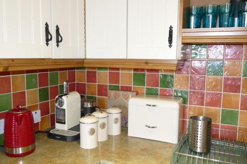 - un comptoir de cuisine avec une cafetière sur un comptoir dans l'établissement Carol Cottage, à Kilkeel