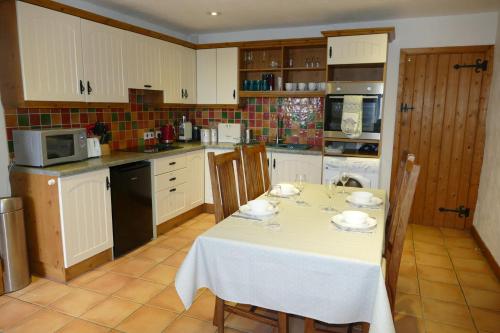 une cuisine avec une table et un chiffon de table blanc dans l'établissement Carol Cottage, à Kilkeel