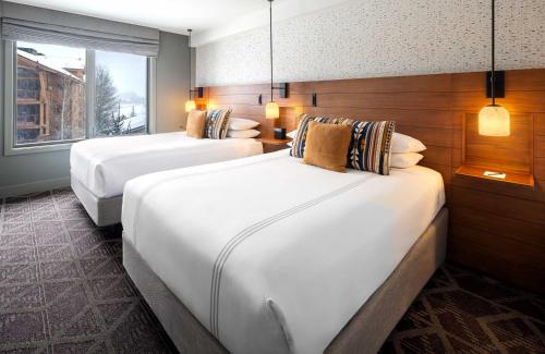 a hotel room with two beds and a window at Hotel Terra Jackson Hole, a Noble House Resort in Teton Village
