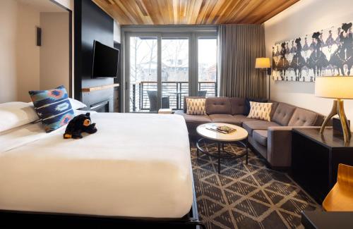 a hotel room with a large bed and a couch at Hotel Terra Jackson Hole, a Noble House Resort in Teton Village