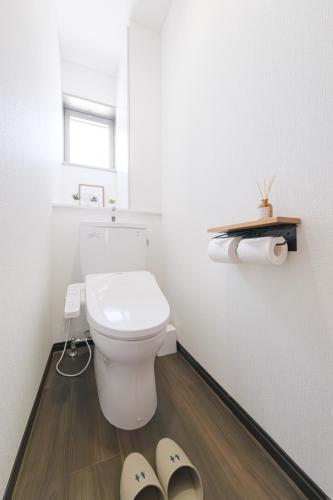 a bathroom with a toilet and a pair of slippers at Jomo Stay Takasaki in Takasaki