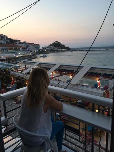 a woman sitting on a cruise ship looking at the water at Anxhelo Apartment in Kokkari